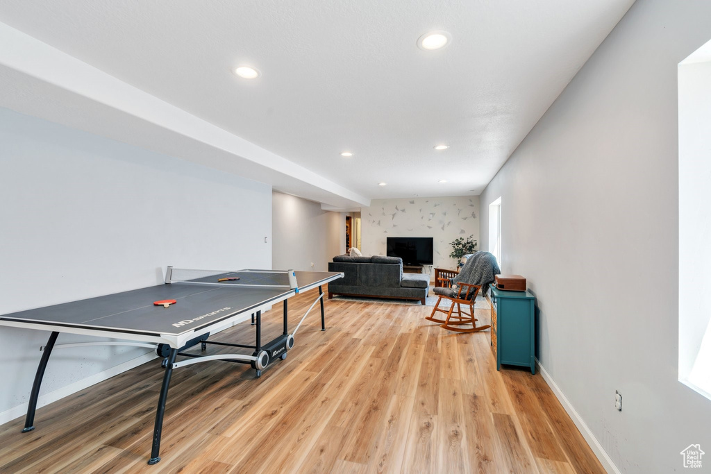 Game room featuring light wood-style flooring, baseboards, recessed lighting, and a fireplace