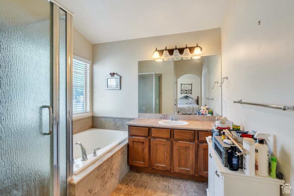 Ensuite bathroom featuring a shower stall, vanity, and a garden tub