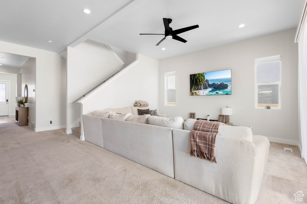 Carpeted living room with stairs, a ceiling fan, recessed lighting, and baseboards