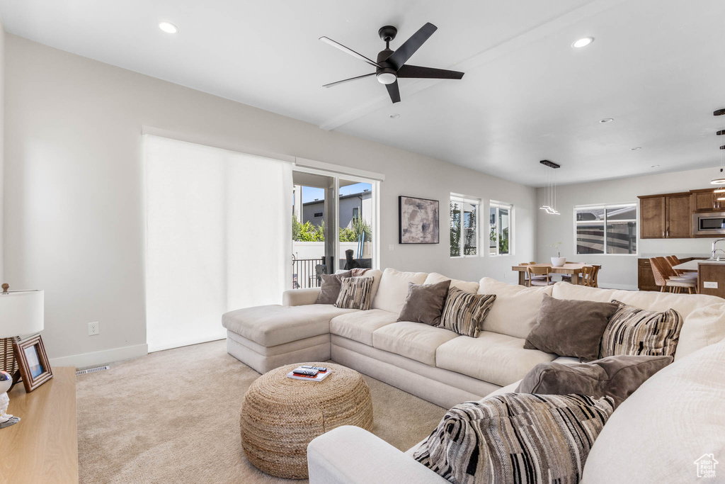 Living room featuring ceiling fan, recessed lighting, baseboards, and light carpet