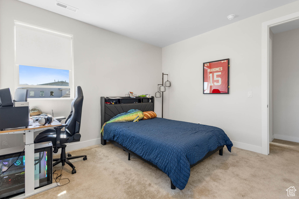 Carpeted bedroom with baseboards and an office area