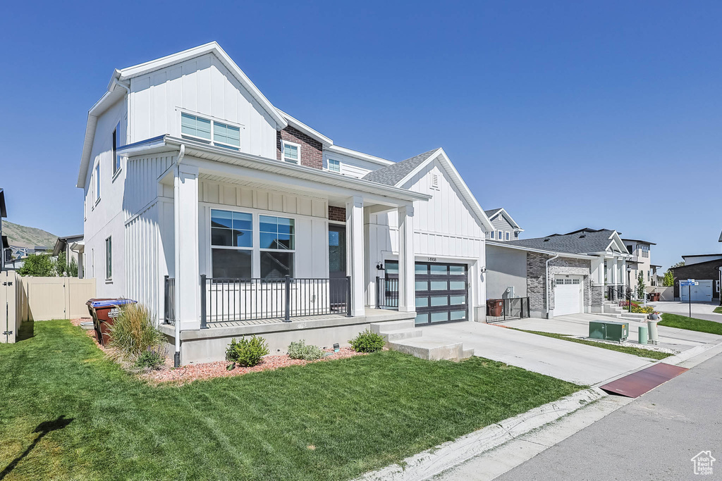 Modern farmhouse style home with covered porch, board and batten siding, and concrete driveway