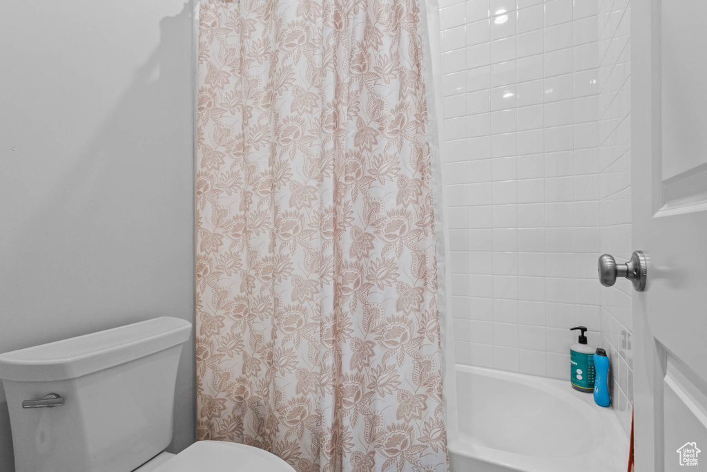 Bathroom featuring toilet and shower / bath combo
