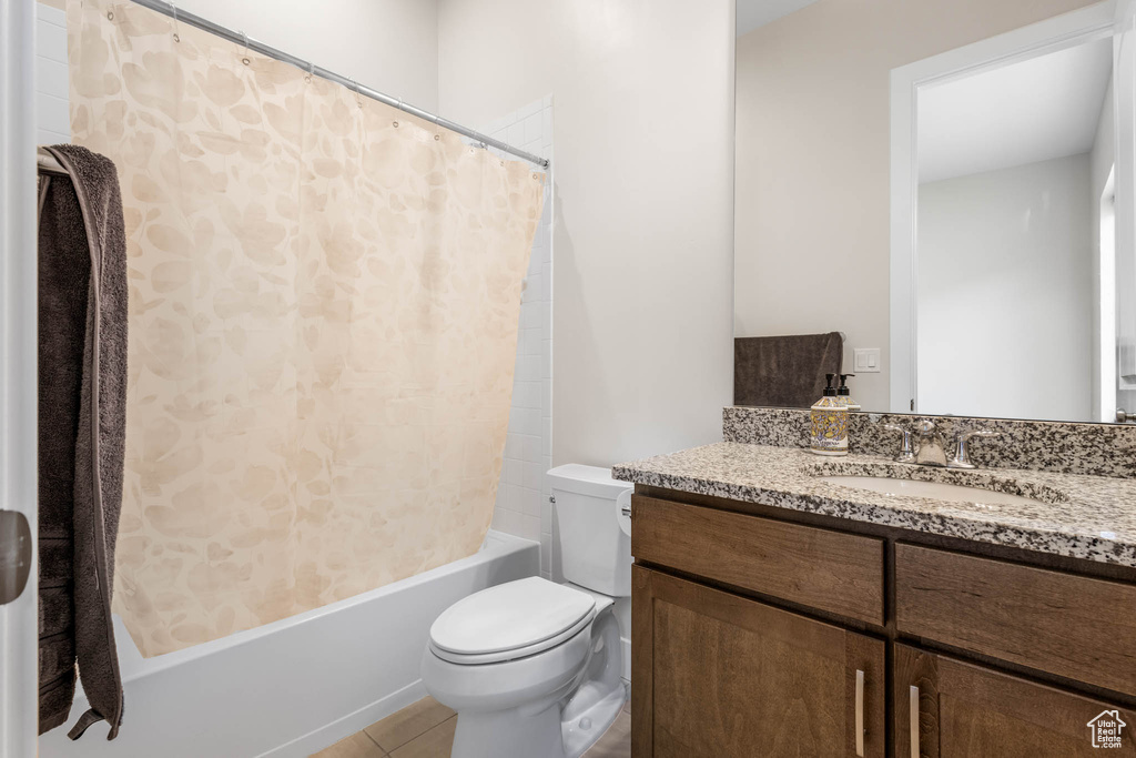 Full bath featuring toilet, vanity, shower / bath combination with curtain, and tile patterned floors