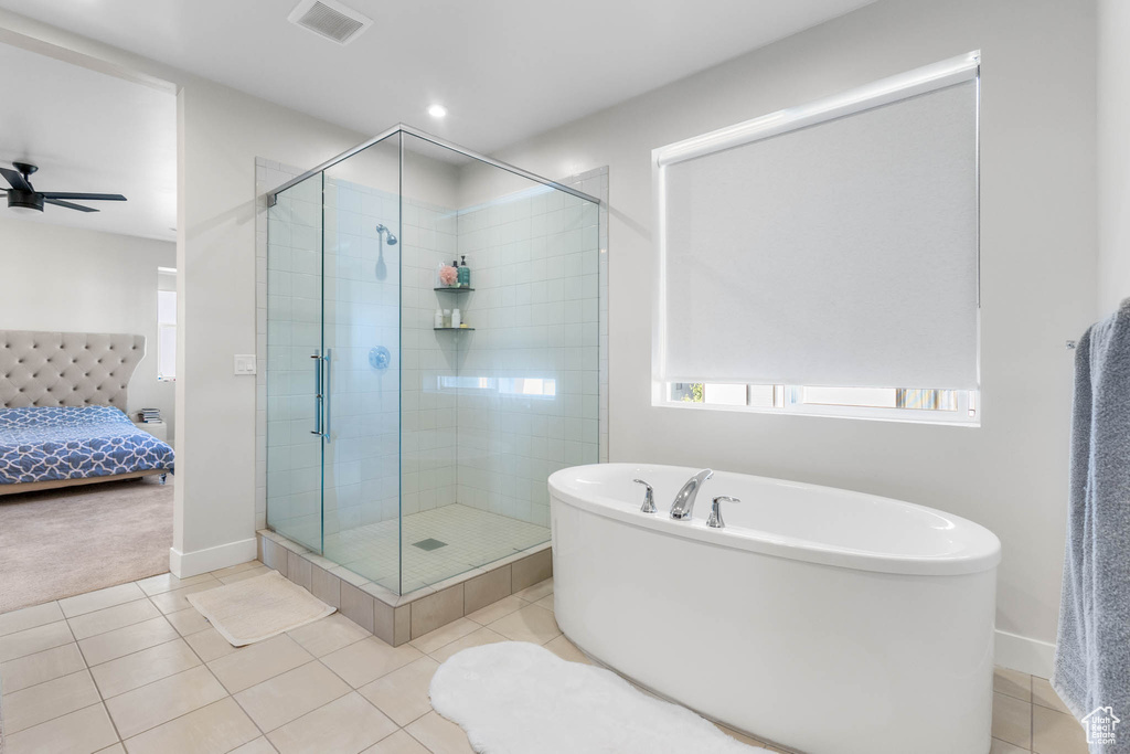 Ensuite bathroom featuring a freestanding bath, a shower stall, tile patterned floors, baseboards, and recessed lighting