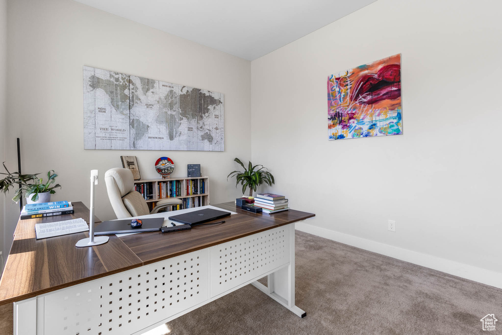 Carpeted home office featuring baseboards