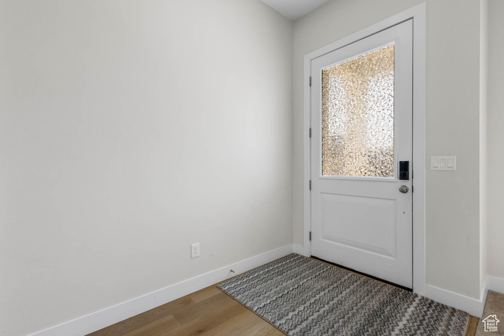 Entryway with baseboards and wood finished floors