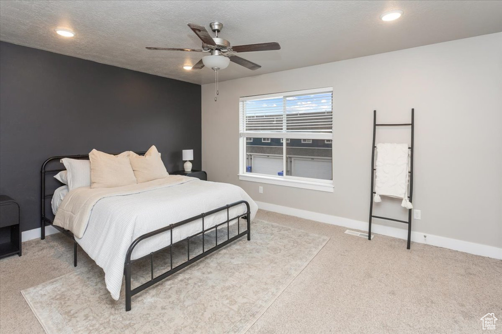 Carpeted bedroom featuring baseboards, a ceiling fan, and recessed lighting
