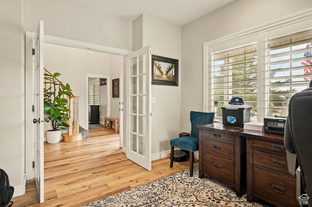 Office area with french doors, light wood-style flooring, and baseboards