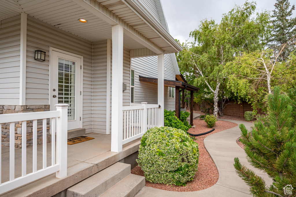 View of exterior entry featuring a porch and stone siding