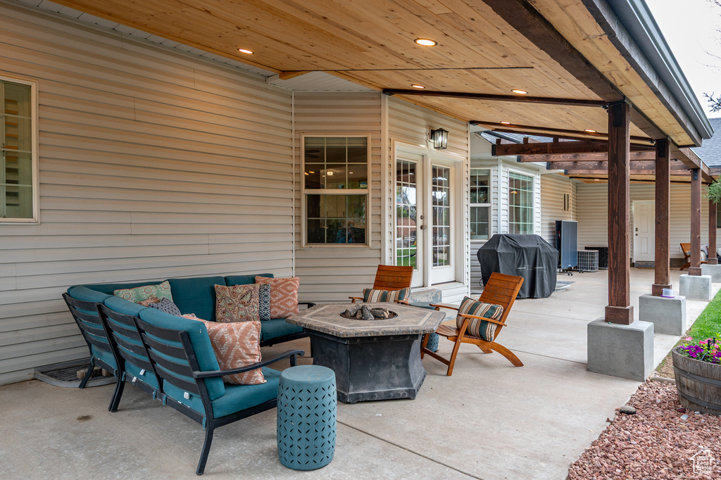 View of patio with grilling area, french doors, and an outdoor living space with a fire pit