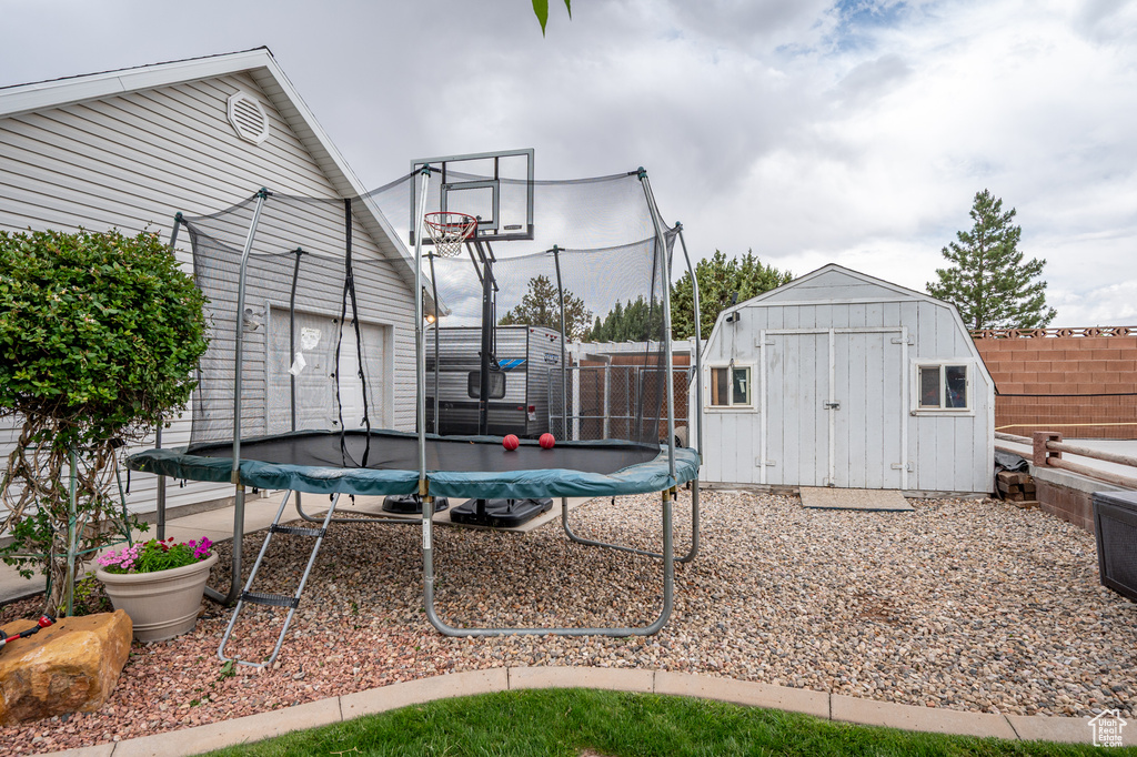 View of basketball court with a trampoline and a storage unit