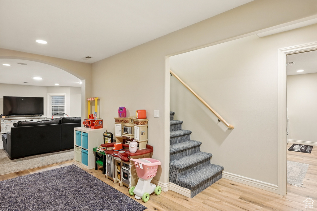 Rec room featuring arched walkways, wood finished floors, recessed lighting, and baseboards