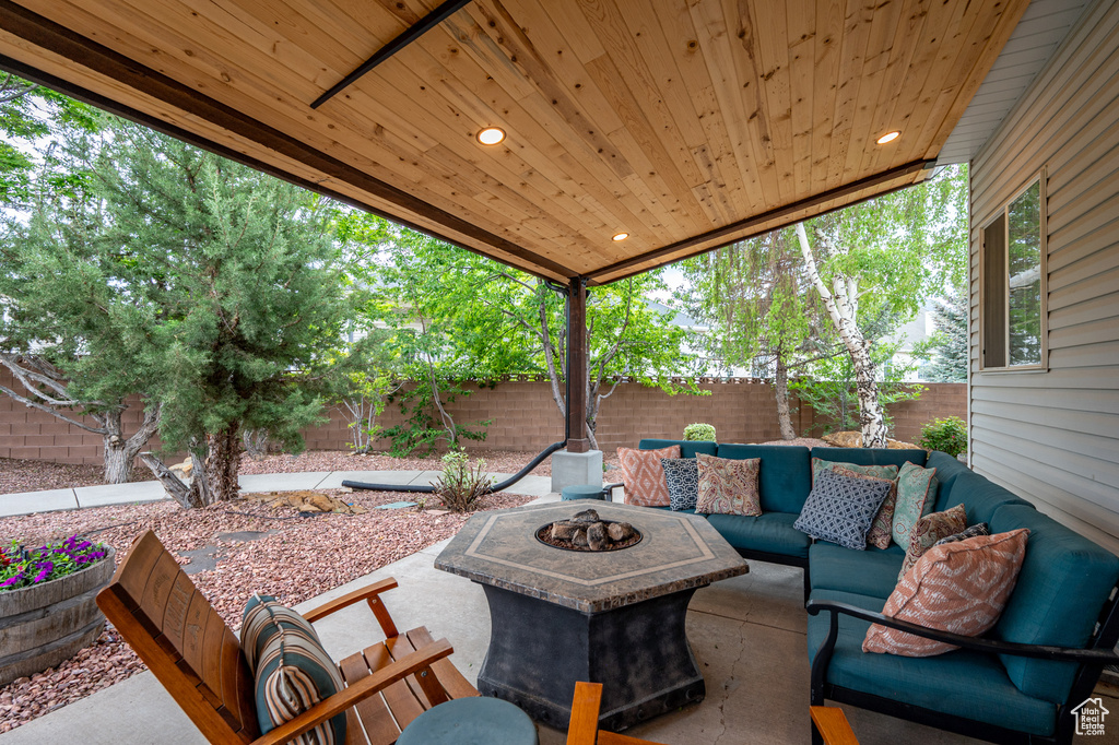 Fenced backyard with an outdoor living space with a fire pit and a patio area