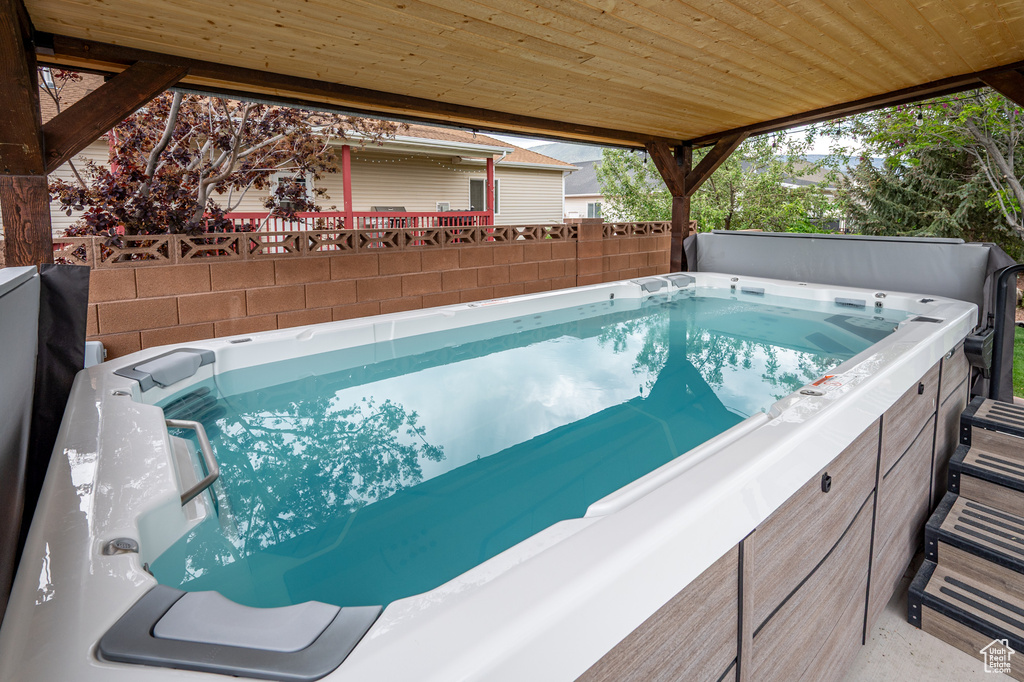 View of swimming pool with a hot tub