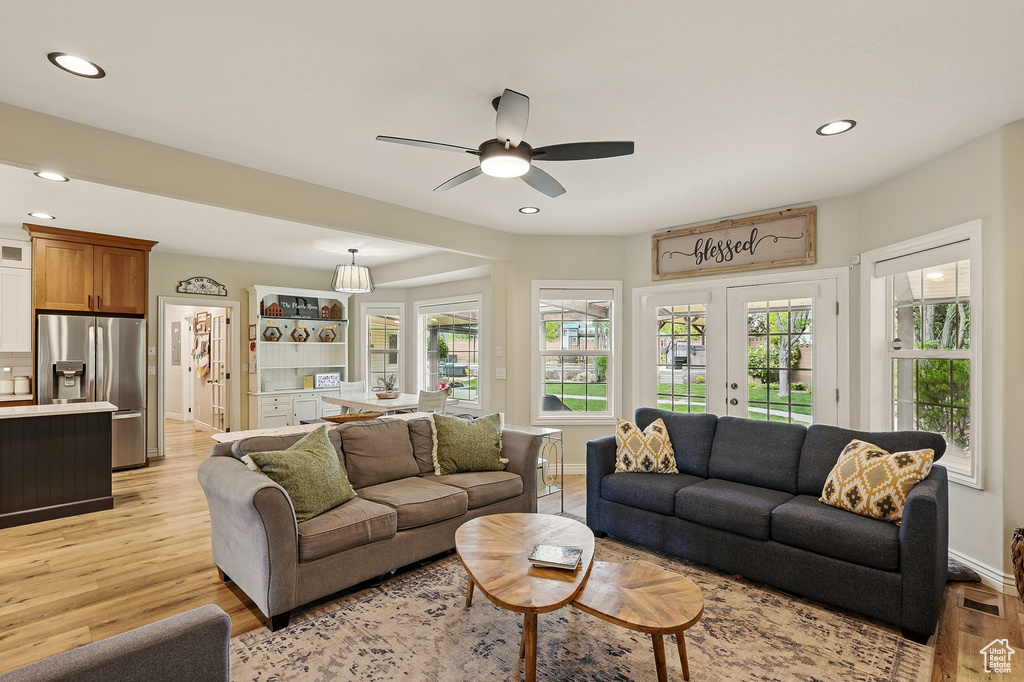 Living area with light wood-type flooring, recessed lighting, baseboards, ceiling fan, and plenty of natural light
