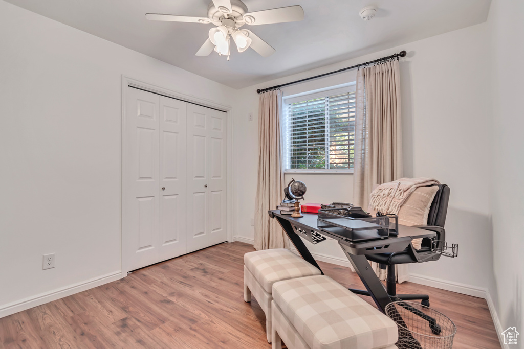 Home office featuring wood finished floors, ceiling fan, and baseboards