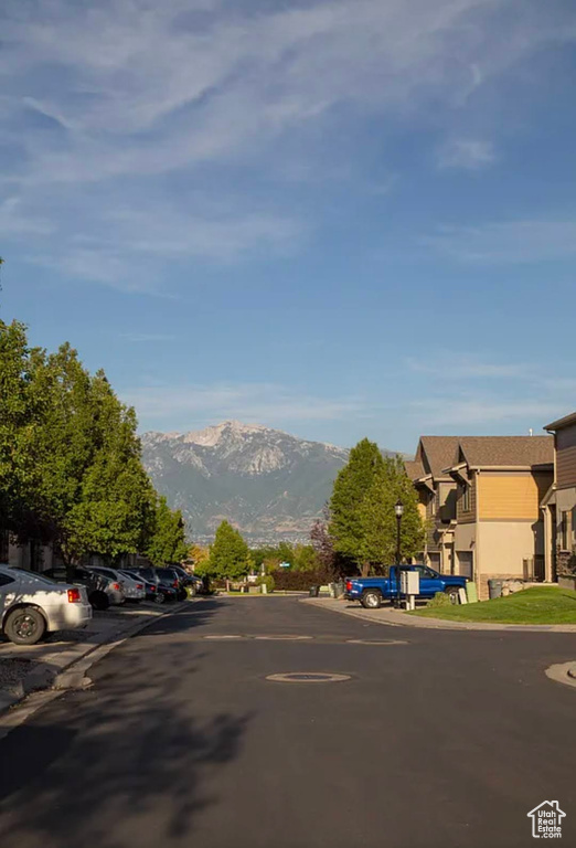 View of asphalt road with a mountain view, street lights, and a residential view