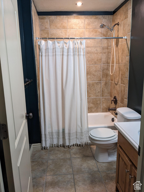 Bathroom with vanity, toilet, and shower / bathtub combination with curtain