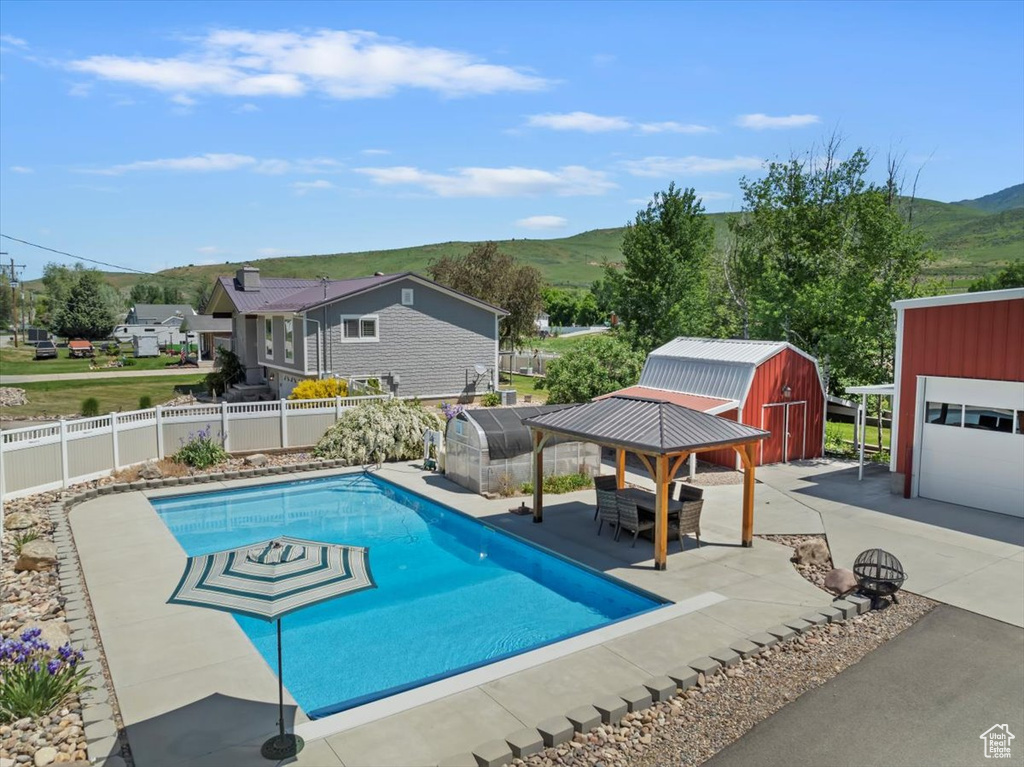 View of swimming pool with a mountain view, a fenced backyard, and a patio