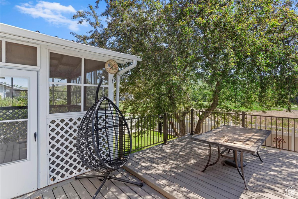 Wooden terrace featuring a sunroom