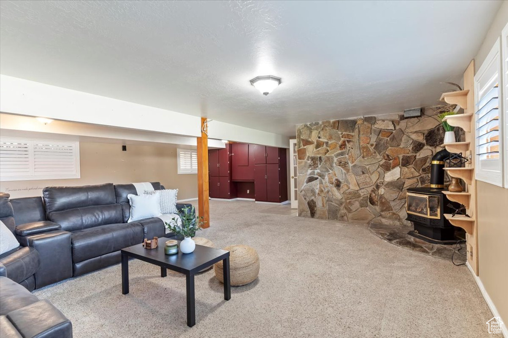 Carpeted living area with healthy amount of natural light and a wood stove