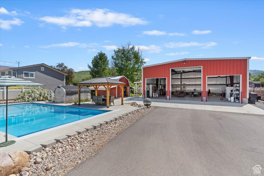 View of swimming pool featuring a gazebo, an outdoor structure, and an outbuilding