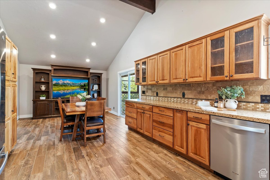 Kitchen featuring dishwasher, light stone counters, decorative backsplash, light wood-style flooring, and recessed lighting