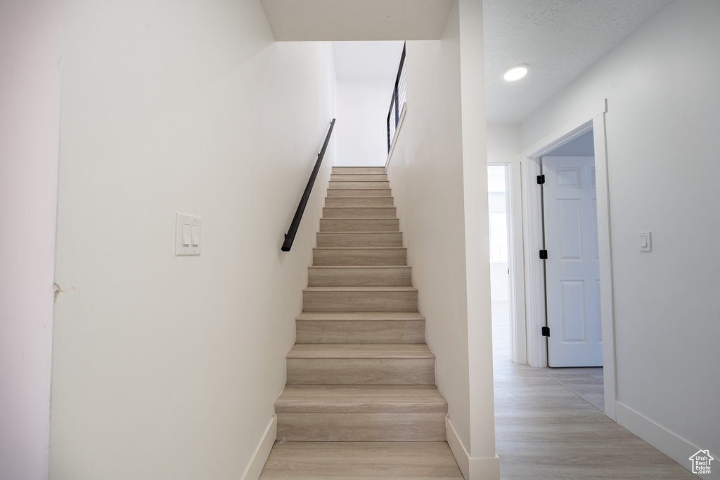 Stairway featuring baseboards and wood finished floors