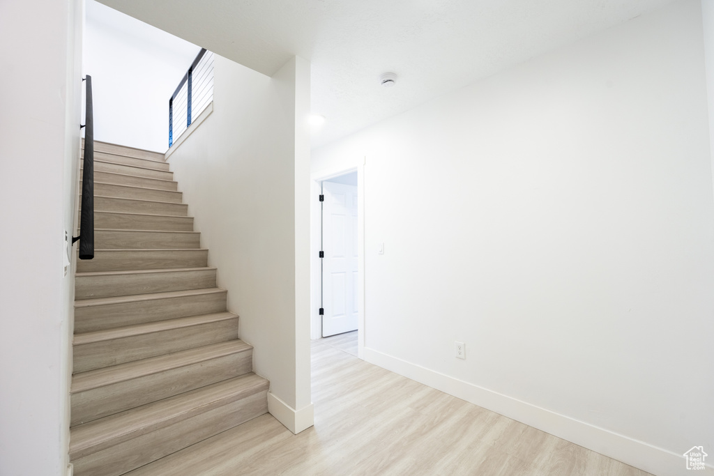 Stairway featuring wood finished floors and baseboards