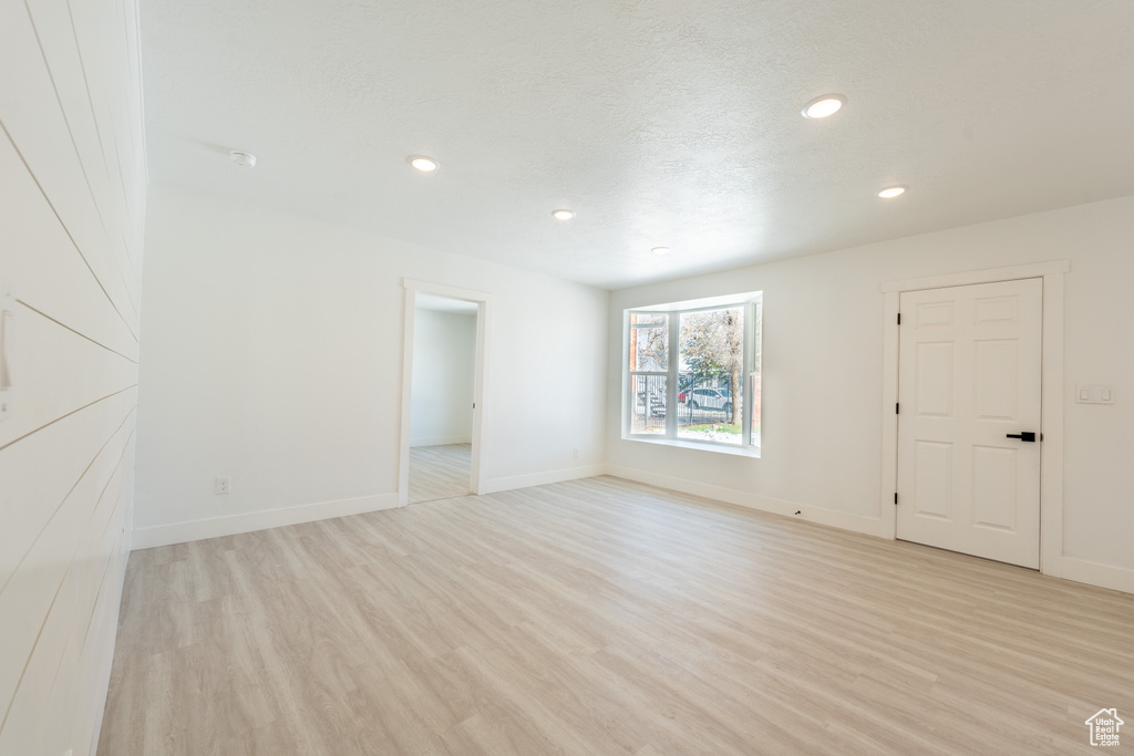 Spare room featuring light wood-style flooring, recessed lighting, and baseboards