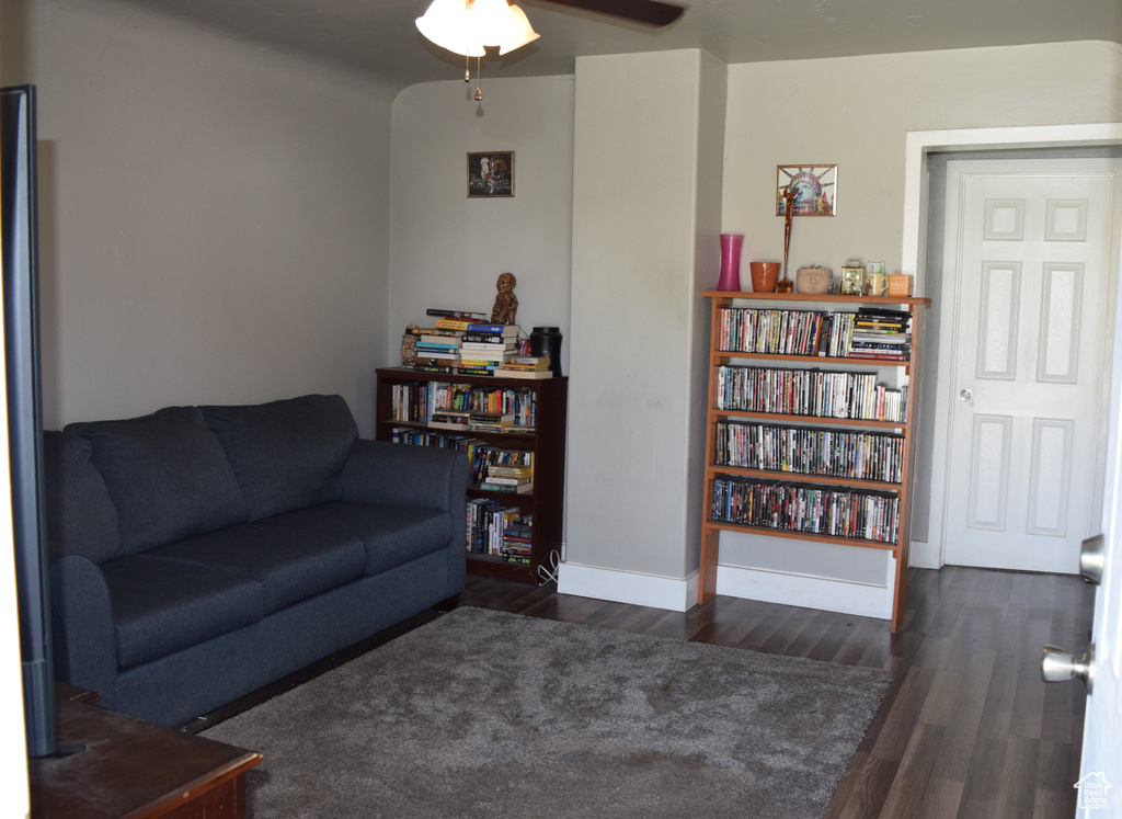 Living room with wood finished floors, ceiling fan, and baseboards