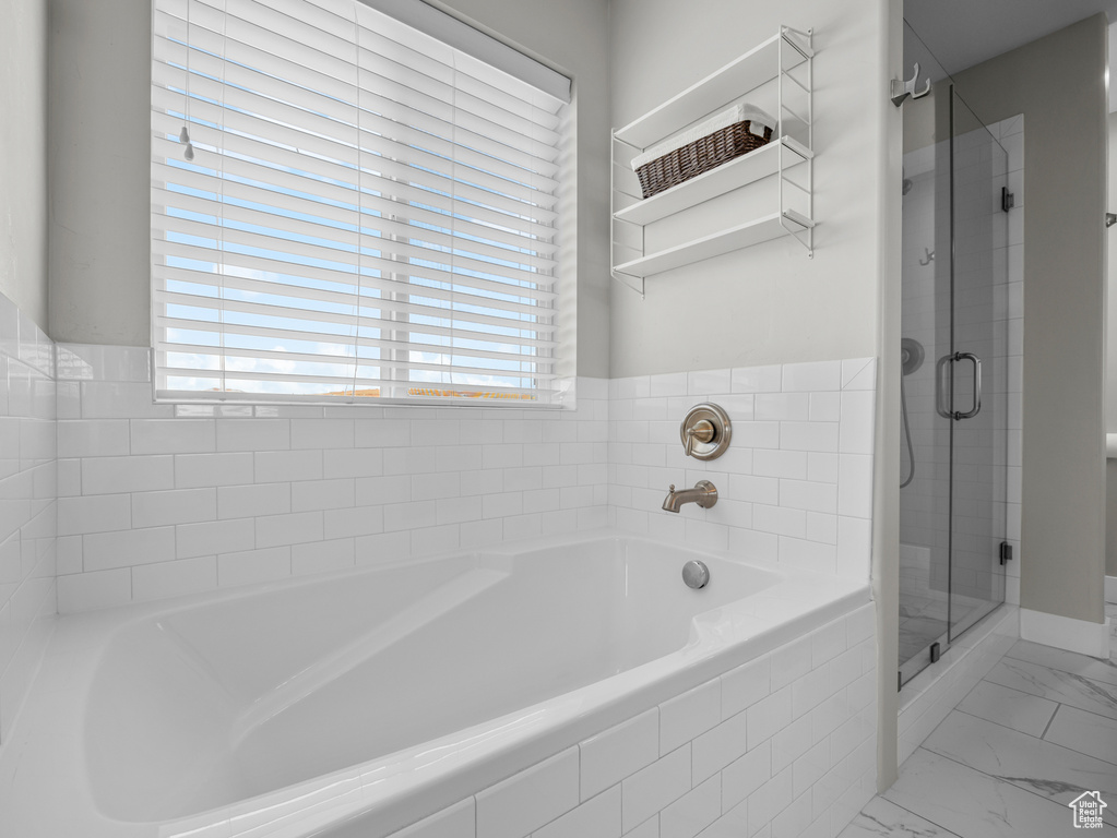 Bathroom with a garden tub, a stall shower, and marble finish floors
