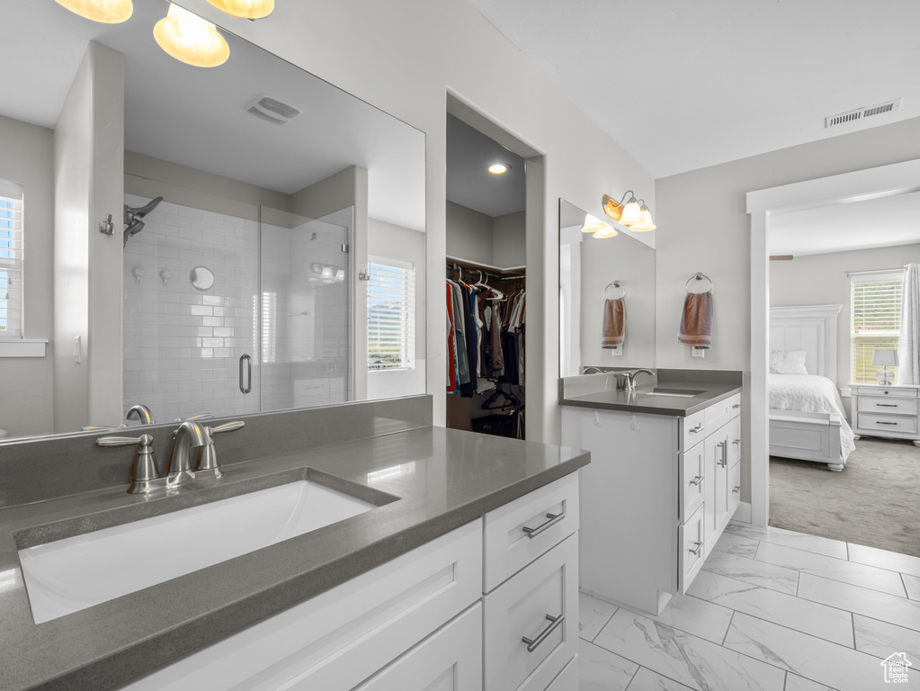 Full bath featuring vanity, a stall shower, marble finish flooring, connected bathroom, and a walk in closet