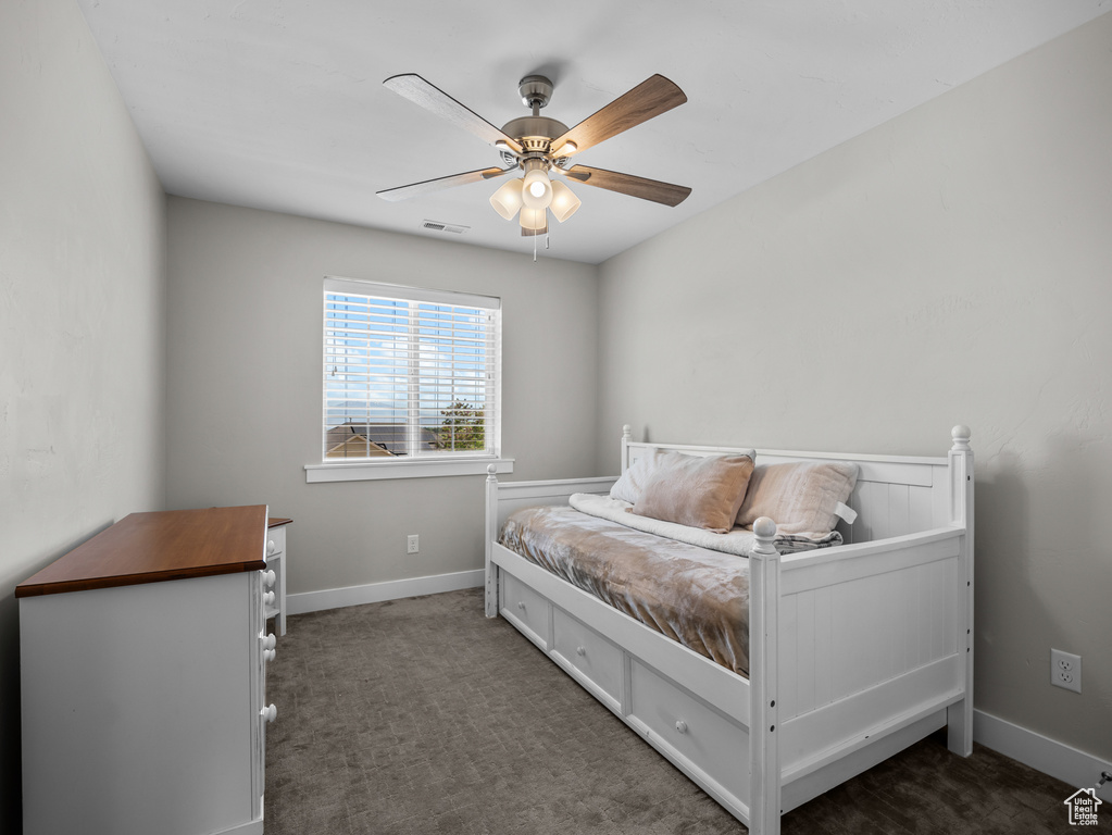 Carpeted bedroom with ceiling fan and baseboards