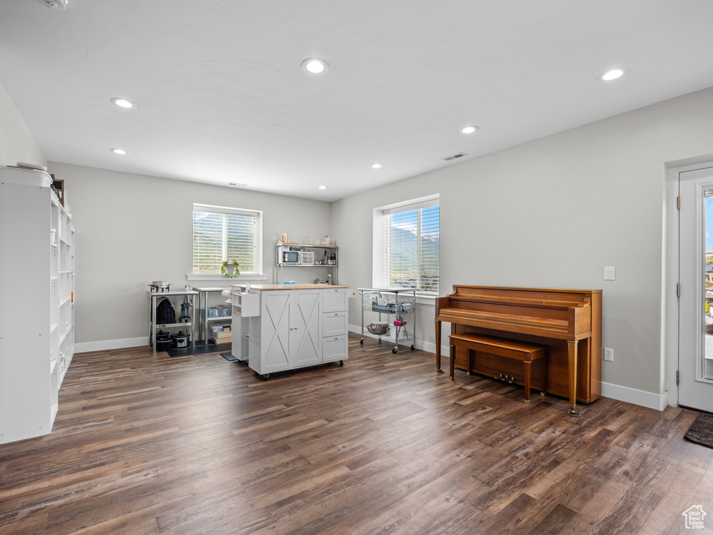 Sitting room with plenty of natural light, dark wood-type flooring, recessed lighting, and baseboards