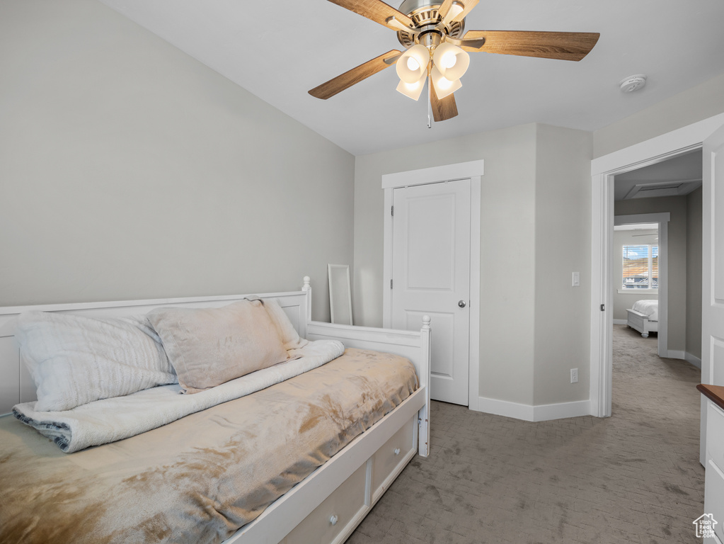Carpeted bedroom featuring baseboards and ceiling fan