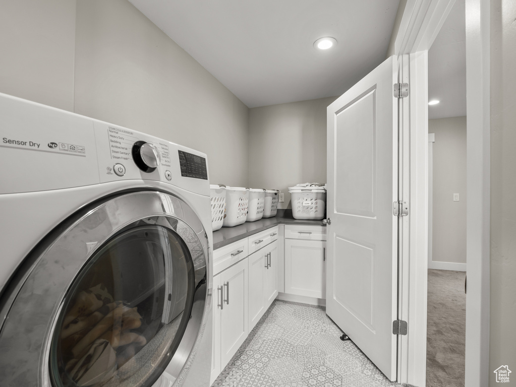 Washroom featuring washer / dryer, cabinet space, and recessed lighting