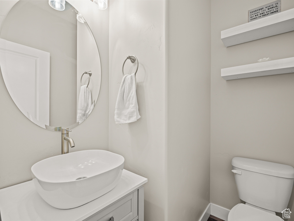 Half bathroom featuring vanity and toilet