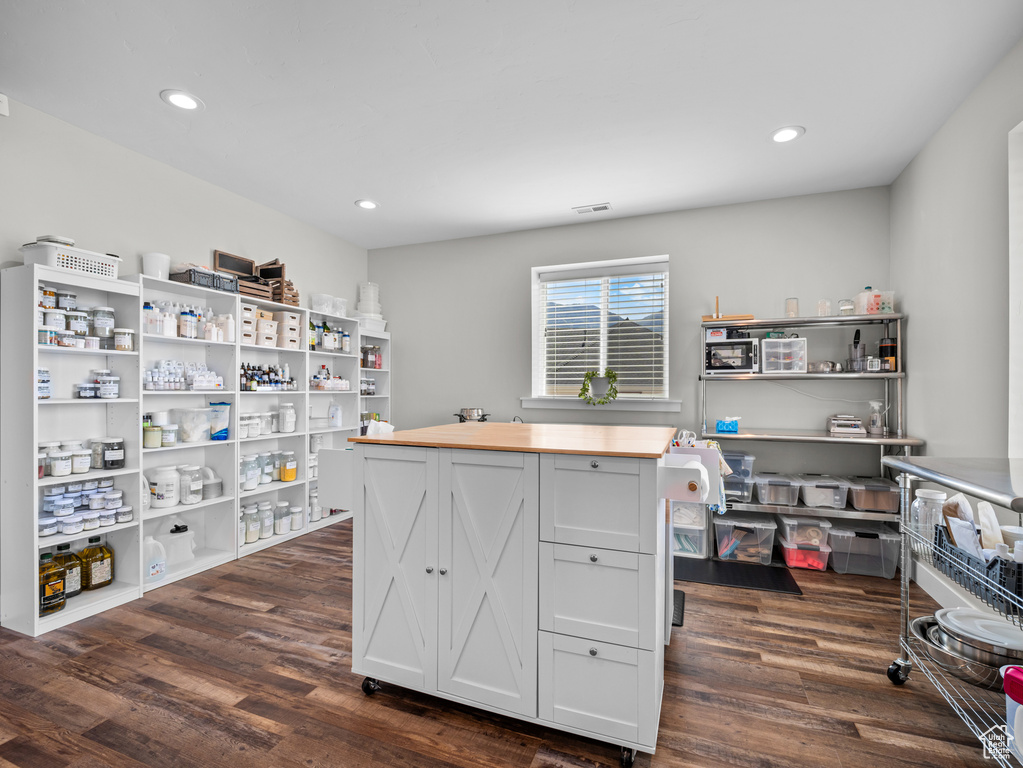 Office space with dark wood-type flooring and recessed lighting