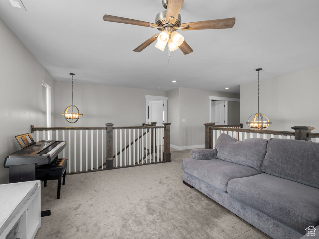 Living room featuring a chandelier, light colored carpet, ceiling fan, recessed lighting, and baseboards