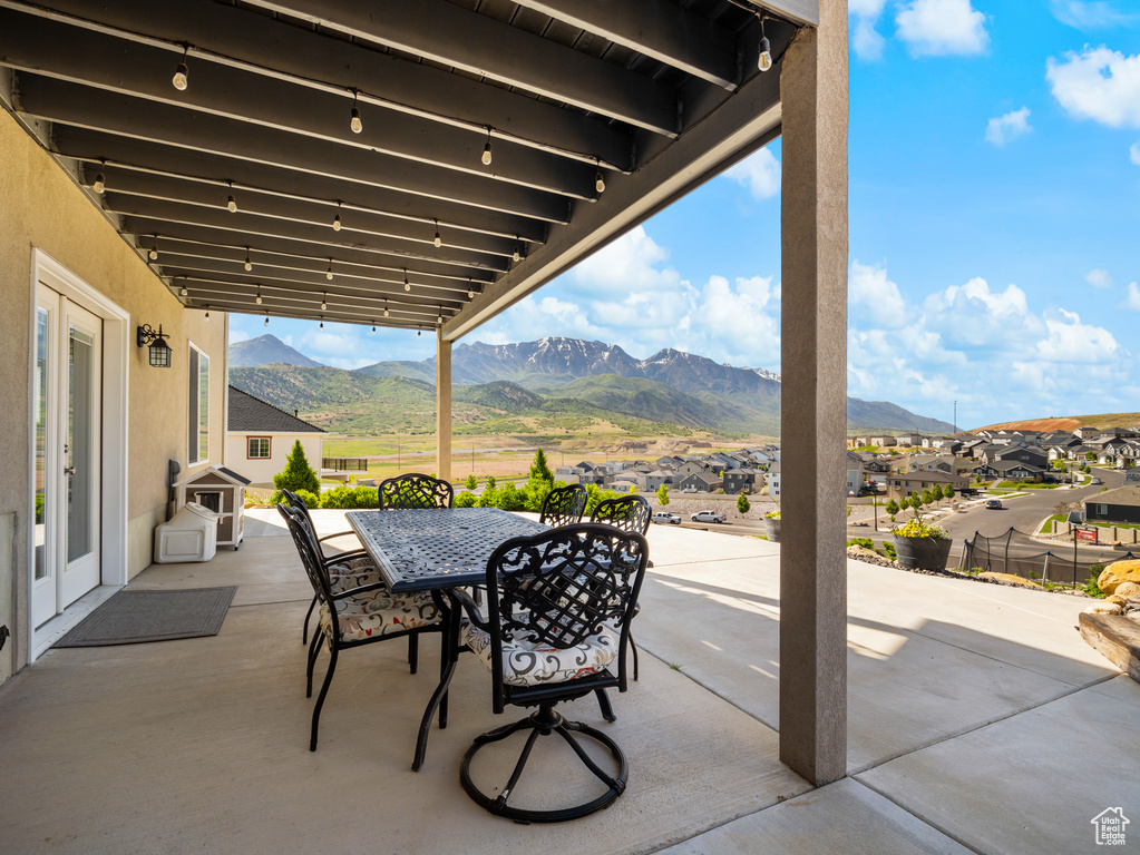 View of patio with a mountain view, outdoor dining area, and a residential view