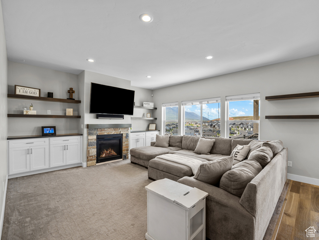 Living area with recessed lighting, a fireplace, light wood-style flooring, and baseboards