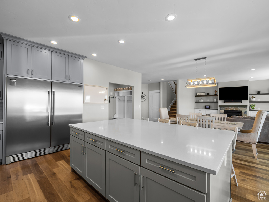 Kitchen with built in fridge, gray cabinets, light countertops, open floor plan, and recessed lighting