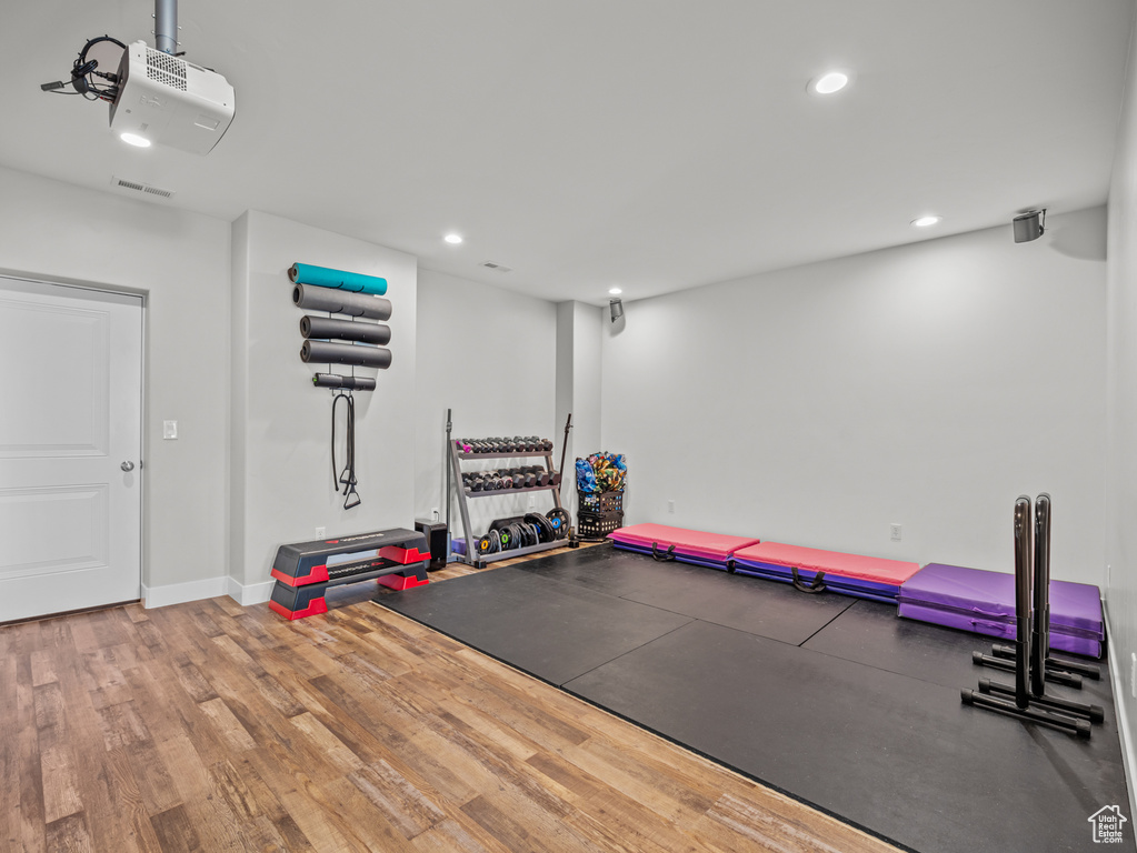 Workout area with wood finished floors, recessed lighting, and baseboards