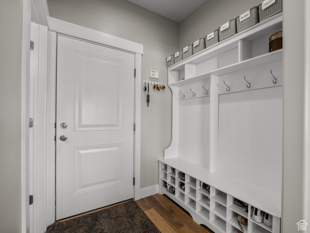 Mudroom featuring dark wood-style flooring and baseboards