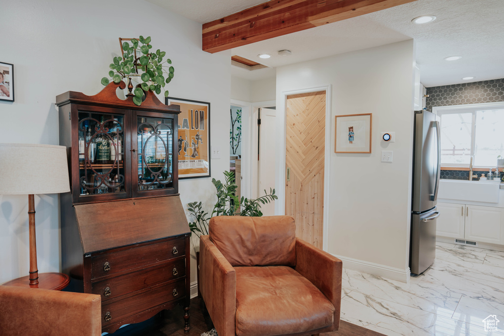 Sitting room featuring recessed lighting, beamed ceiling, and marble finish floors