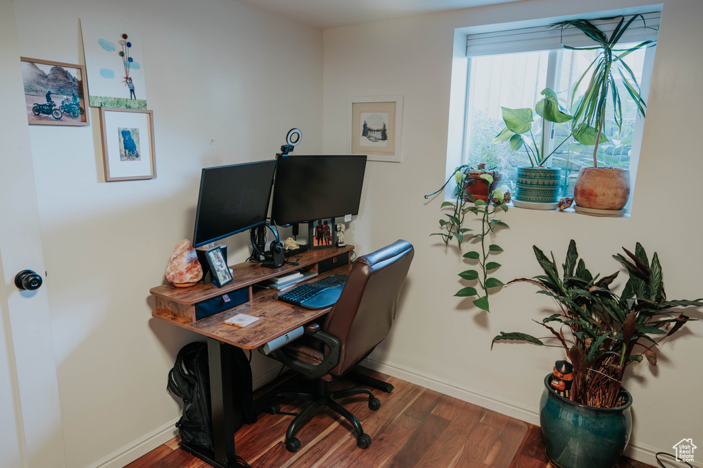 Home office with dark wood-type flooring and baseboards