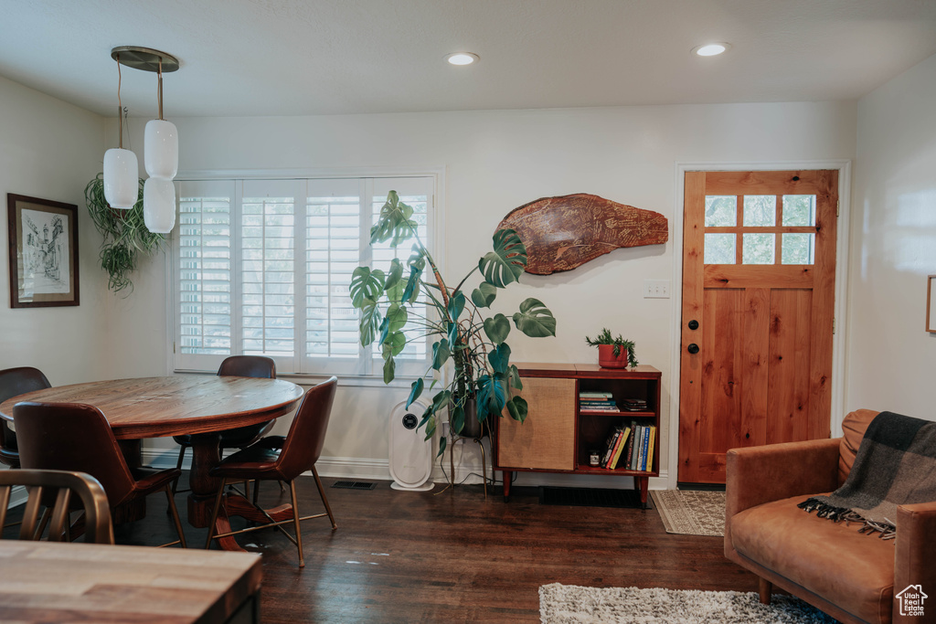 Dining space with dark wood finished floors and recessed lighting