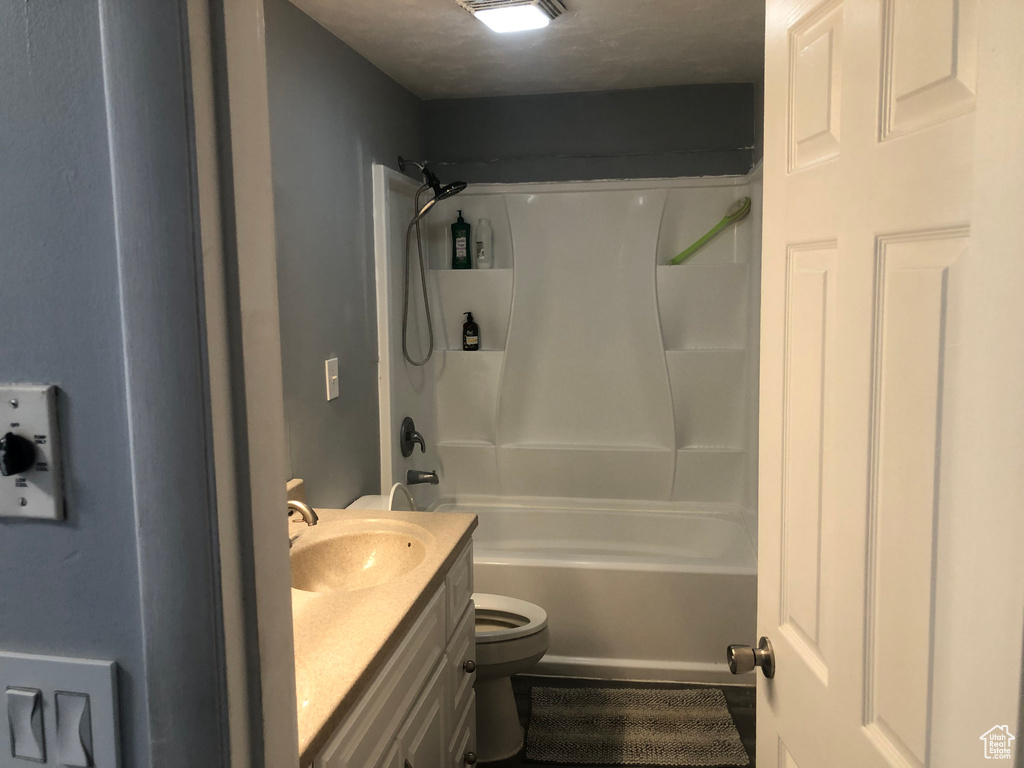 Bathroom featuring toilet, vanity, and bathtub / shower combination